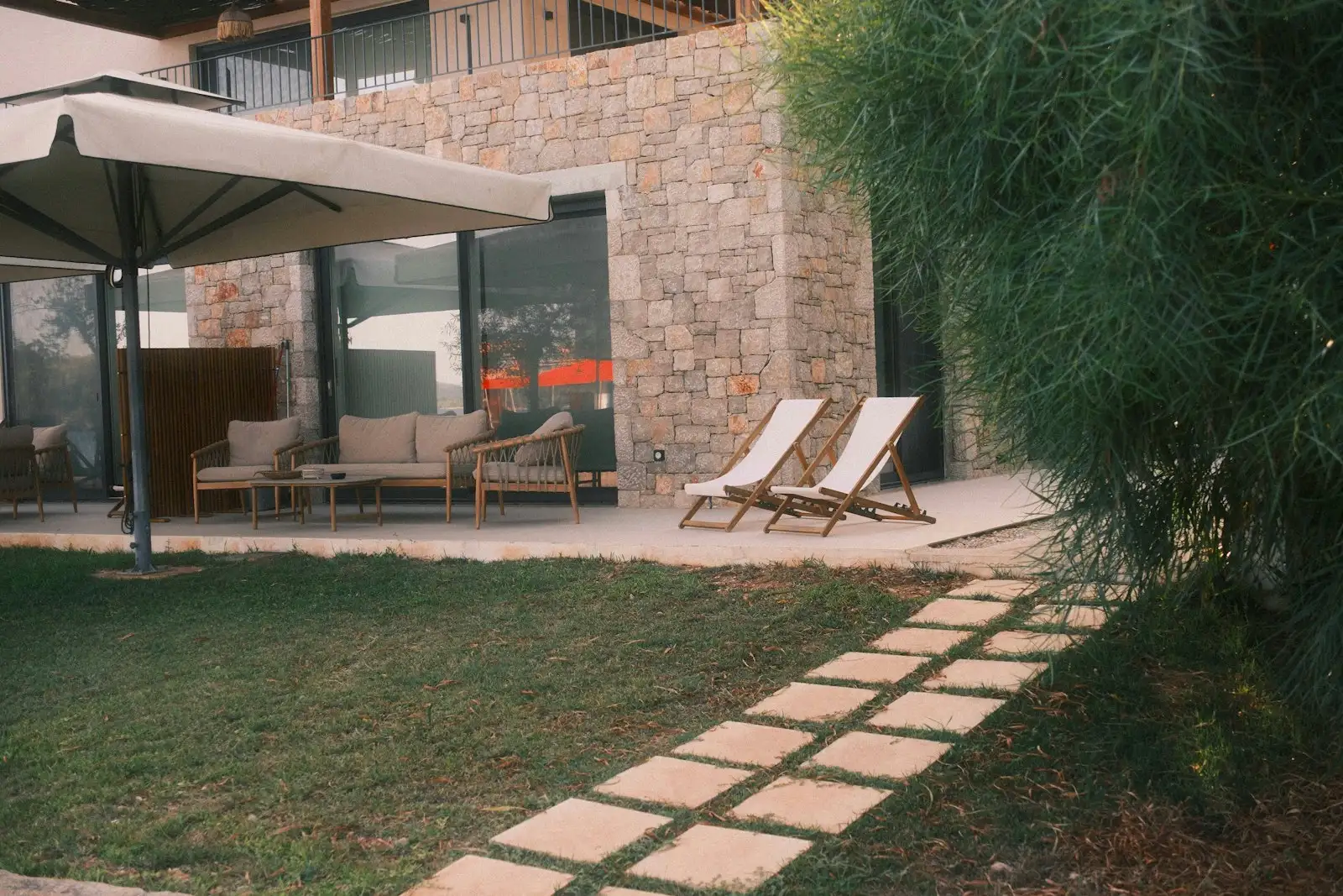Après : Terrasse terminée avec chaises longues et pas japonais dans le gazon